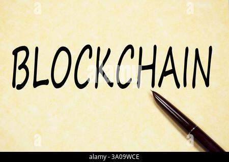 Handwritten word BLOCKCHAIN on aged parchment paper with dark fountain pen Stock Photo