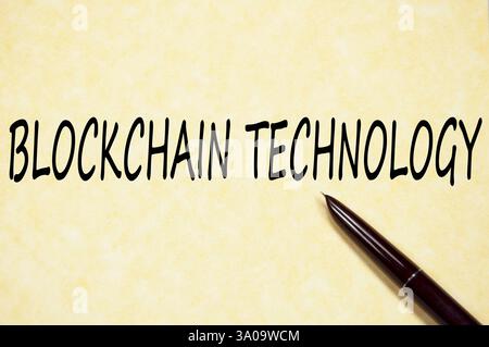 Handwritten phrase BLOCKCHAIN TECHNOLOGY on vintage parchment paper with pen Stock Photo
