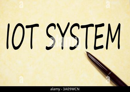 Handwritten text IOT SYSTEM on aged parchment paper with fountain pen Stock Photo