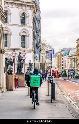 Uber Eats food delivery courier cycling on the pavement across Holborn Viaduct in Central London. Stock Photo