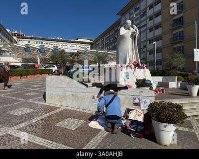 Rom, Italy. 03rd Mar, 2025. A man kneels in front of the monument to Pope John Paul II on the grounds of the Agostino Gemelli Polyclinic, where Pope Francis has been receiving treatment since mid-February. Credit: Christoph Sator/dpa/Alamy Live News Stock Photo