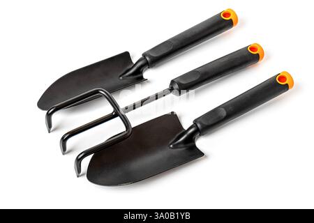 Small gardening tools set with trowel, hand rake and cultivator lying on white background, ready for planting Stock Photo
