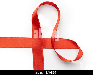 Red ribbon forming heart shape over white background, ideal for valentine's day, gifts, or celebrations Stock Photo