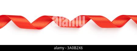 Red satin ribbon forming elegant curves, ideal for festive decorations or gift wrapping Stock Photo