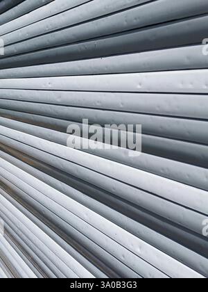 Hail marks create texture on metal roller shutter  after severe weather event Stock Photo
