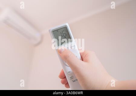 Woman controls smart home with a remote, creating a comfortable atmosphere in her home. Stock Photo