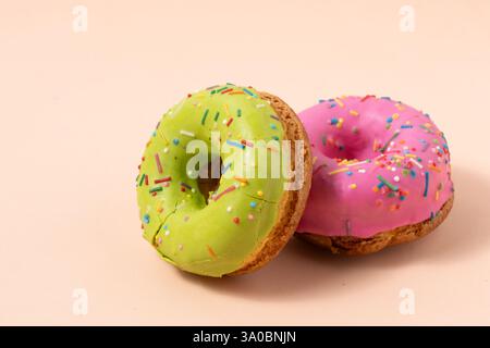 Two colorful donuts on pastel background. Sweet icing sugar food Stock Photo