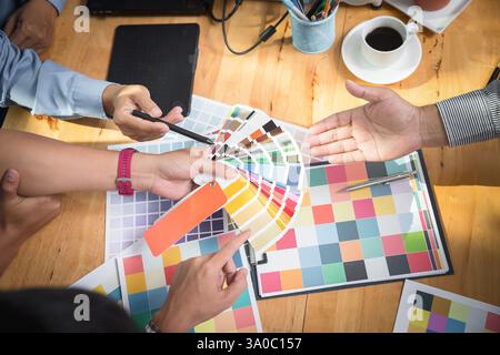 Interior designer chooses a color chart for home design. Graphic designers working on color chart at modern office. Stock Photo