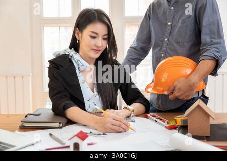 Group of two coworkers working with blueprint in office. co-working teamwork concept. Stock Photo
