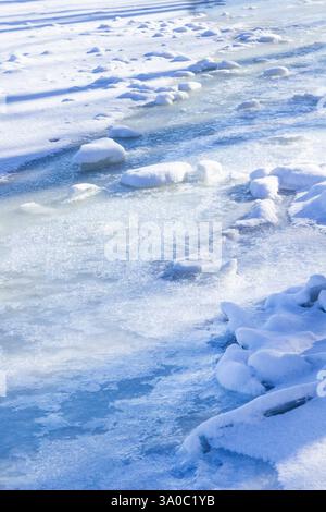 The river is covered with ice. Long shadows on the ice. Stock Photo