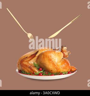 Cutlery in air over plate with roasted turkey on pastel brown background Stock Photo