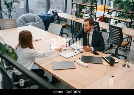 Man in suit is working with woman in the office. Stock Photo