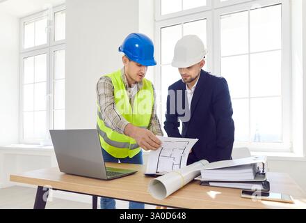 Engineer discussing with foreman design project for housing working on building site Stock Photo