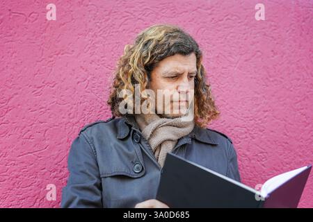 mature student reading a book concentrated on book day in catalonia. Sant Jordi Stock Photo