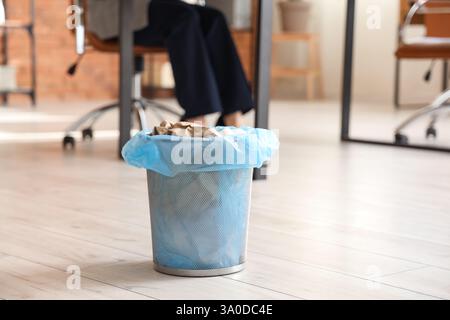 Trash bin full of crumpled paper in office, closeup Stock Photo