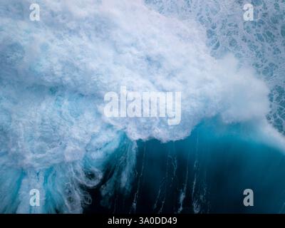 Abstract aerial view of turbulent waves crashing with deep blue green hues of tropical ocean waters Stock Photo