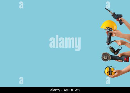 Many hands with construction tools on blue background Stock Photo