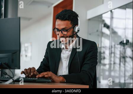 Indian man is sitting and working in the car showroom. Stock Photo