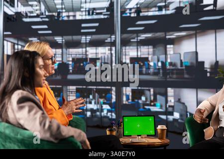 Group of multiethnic women working hard to prove themselves next to chroma key, fighting for success in a men dominated business industry. Diverse colleagues ensuring firm expansion. Stock Photo