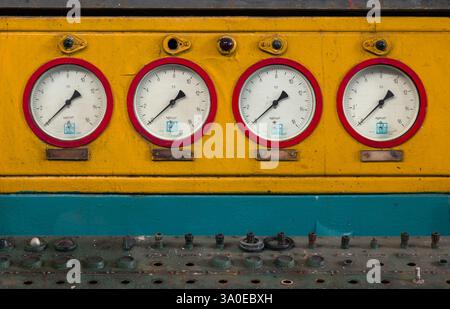 A row of industrial pressure gauges on a panel. Manometers Stock Photo