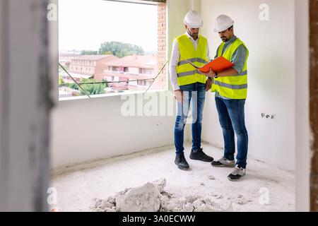 Engineers reading documents inside building under construction Stock Photo