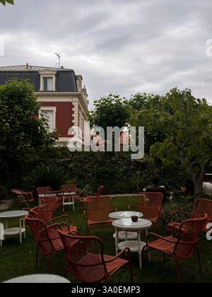 A serene outdoor caf scene featuring charming seating amidst greenery Stock Photo