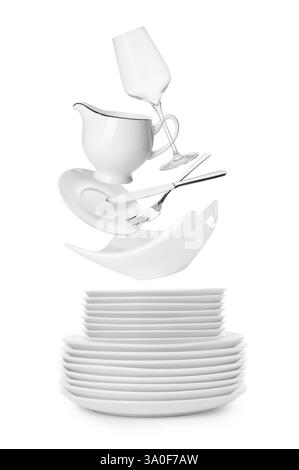 Clean dishware, glass and silverware flying over plates on white background Stock Photo