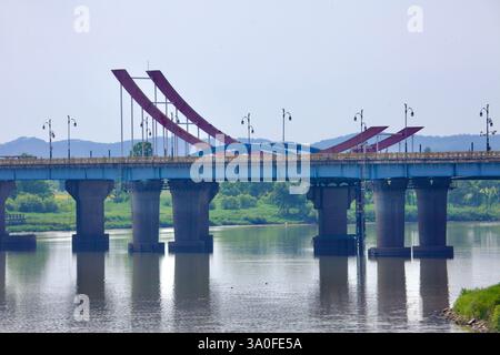Buyeo County, South Korea - May 27, 2021: A close-up view of Baekje Bridge spanning the Geum River, showcasing its striking red and blue sculptural el Stock Photo