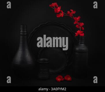 Crockery items displayed on a background with flowers. Still life photography Stock Photo