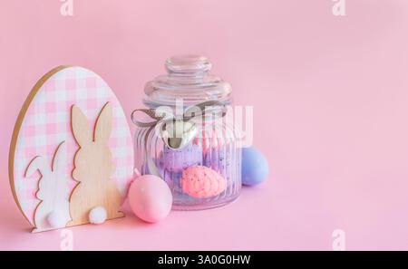 Easter concept, wooden bunny figurine and easter eggs on pink background with copy space Stock Photo