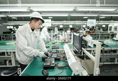 HAIAN, CHINA - MARCH 4, 2025 - A worker produces consumer lithium battery products in a workshop in Hai'an, Jiangsu province, China, March 4, 2025. Stock Photo