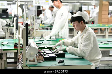 HAIAN, CHINA - MARCH 4, 2025 - A worker produces consumer lithium battery products in a workshop in Hai'an, Jiangsu province, China, March 4, 2025. Stock Photo