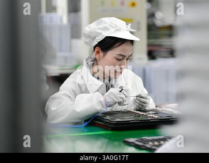 HAIAN, CHINA - MARCH 4, 2025 - A worker produces consumer lithium battery products in a workshop in Hai'an, Jiangsu province, China, March 4, 2025. Stock Photo