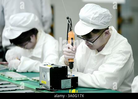 HAIAN, CHINA - MARCH 4, 2025 - A worker produces consumer lithium battery products in a workshop in Hai'an, Jiangsu province, China, March 4, 2025. Stock Photo