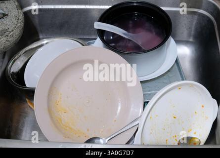 Mess in the kitchen, lot of dirty dishes in the sink. Stock Photo