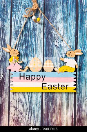 wooden flower plate merry Easter with rabbits and colorful eggs Stock Photo