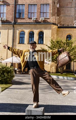 A fashionable senior man is seen confidently walking on a city street, balancing on one foot. Stock Photo