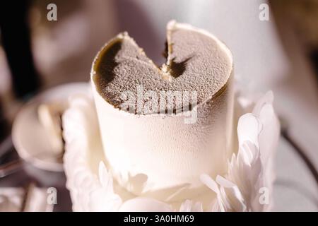 Close-up of a partially eaten wedding cake, featuring a white mousse texture and adorned with delicate feather-like decorations Stock Photo