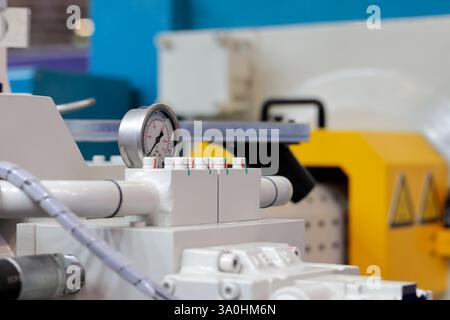 Modern manufacturing equipment and analog pressure gauge. Close up of plastic injection molding press machine. Selective focus. Stock Photo