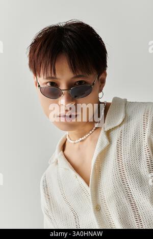 A young, stylish Asian man poses confidently with unique accessories. Stock Photo