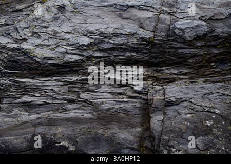 Low key, closeup photo of layers of natural slate. Norwegian rocks in natural environment. Stock Photo