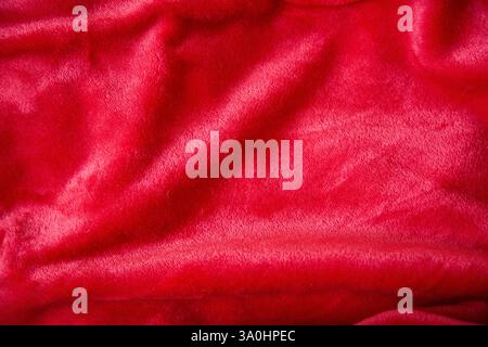 Red shimmering plush fabric colour, close-up texture. Stock Photo