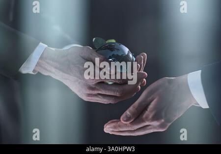 mock-up of the world in hands with a man on a black background Stock Photo