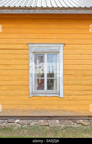 White framed window on a yellow painted old wooden house, Finland. Stock Photo
