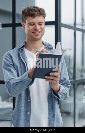 young office man at workplace making notes Stock Photo