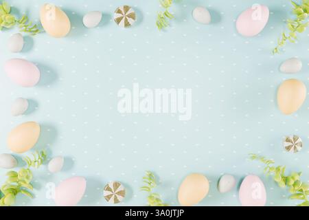 Easter themed arrangement of colorful eggs and greenery on a light blue background. 3d rendering Stock Photo