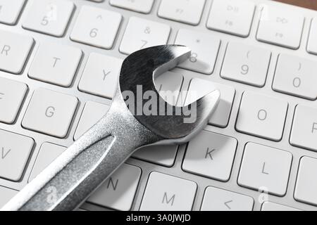 Technical support concept. Wrench on keyboard, closeup Stock Photo