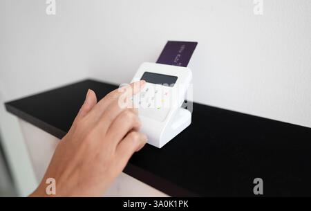 Woman's hand entering a PIN code on a wireless payment terminal Stock Photo