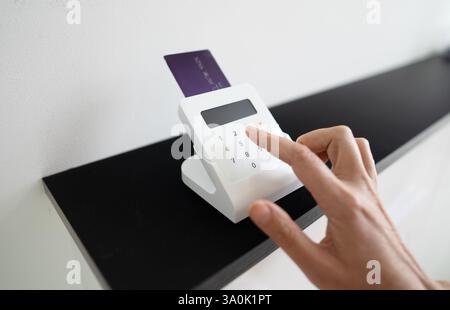 Woman's hand entering a PIN code on a wireless payment terminal Stock Photo