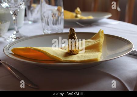 Elegant Easter Table Setting with Golden Chocolate Bunny on Yellow Napkin – Festive Holiday Dining, Spring Celebration, Fine Decor and Cozy Atmosphere Stock Photo